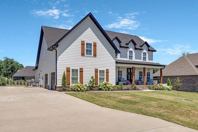 view of front facade with covered porch, a garage, and a front yard