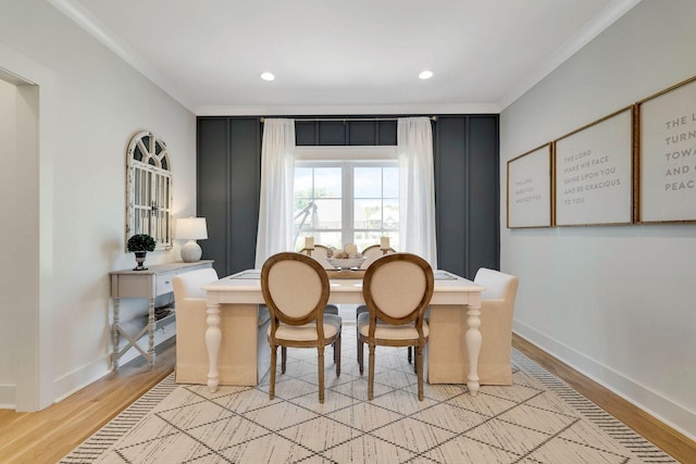 dining area with light wood-type flooring and crown molding