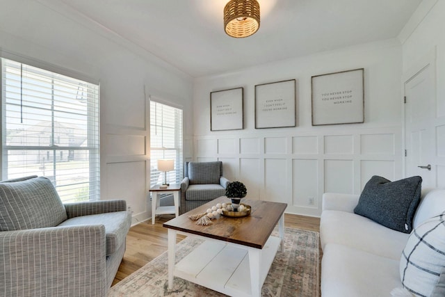 living room with hardwood / wood-style floors, a wealth of natural light, and crown molding