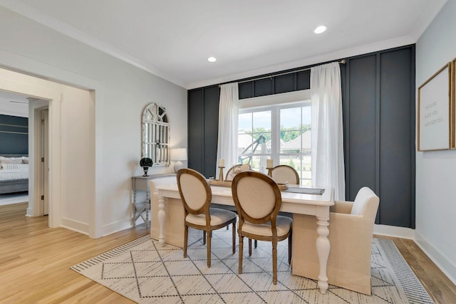 dining area with light hardwood / wood-style flooring and crown molding