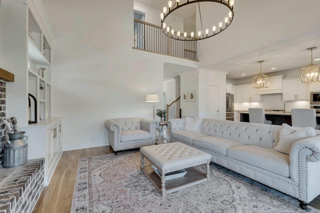 living room featuring a towering ceiling and light hardwood / wood-style floors