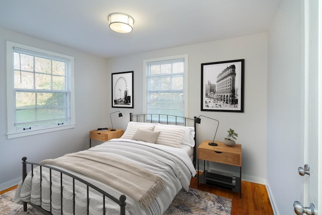 bedroom featuring multiple windows and dark wood-type flooring