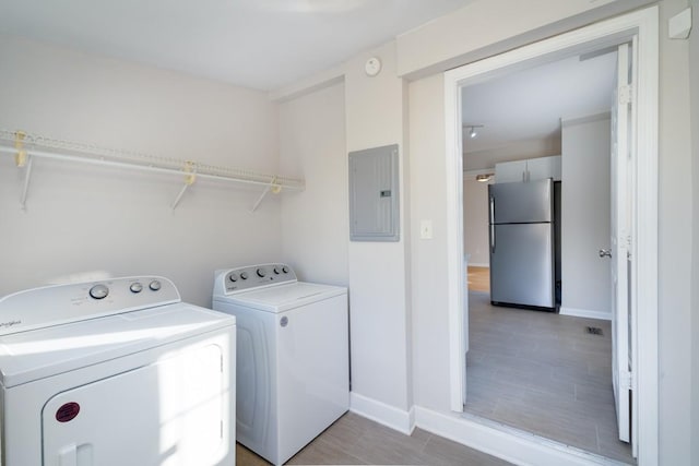 clothes washing area with washer and dryer, tile patterned flooring, and electric panel