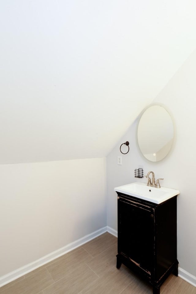 bathroom with vanity and lofted ceiling