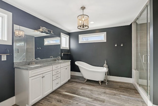 bathroom with ornamental molding, vanity, separate shower and tub, hardwood / wood-style flooring, and a notable chandelier