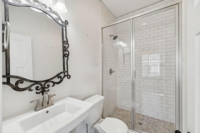 bathroom featuring toilet, sink, and walk in shower