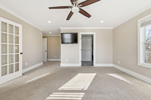 carpeted empty room with ceiling fan and crown molding