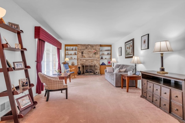 living room with light carpet, built in shelves, and a stone fireplace