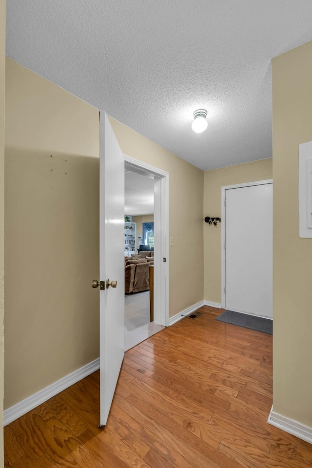 corridor featuring hardwood / wood-style flooring and a textured ceiling