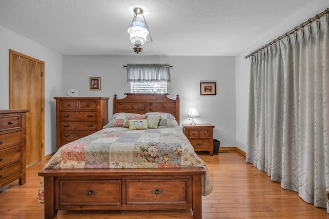 bedroom featuring light hardwood / wood-style flooring and a textured ceiling