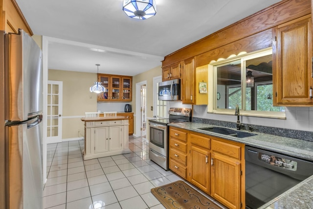 kitchen featuring light tile patterned flooring, decorative light fixtures, stainless steel appliances, and sink