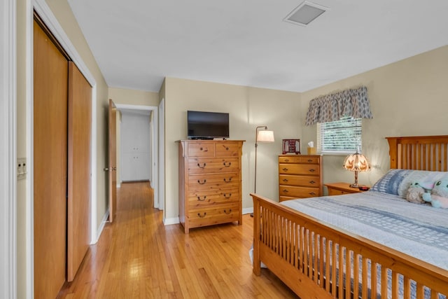 bedroom with light hardwood / wood-style flooring and a closet