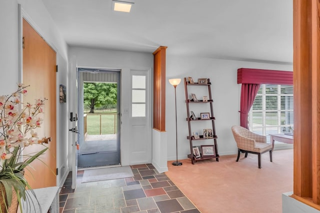 entrance foyer with dark colored carpet