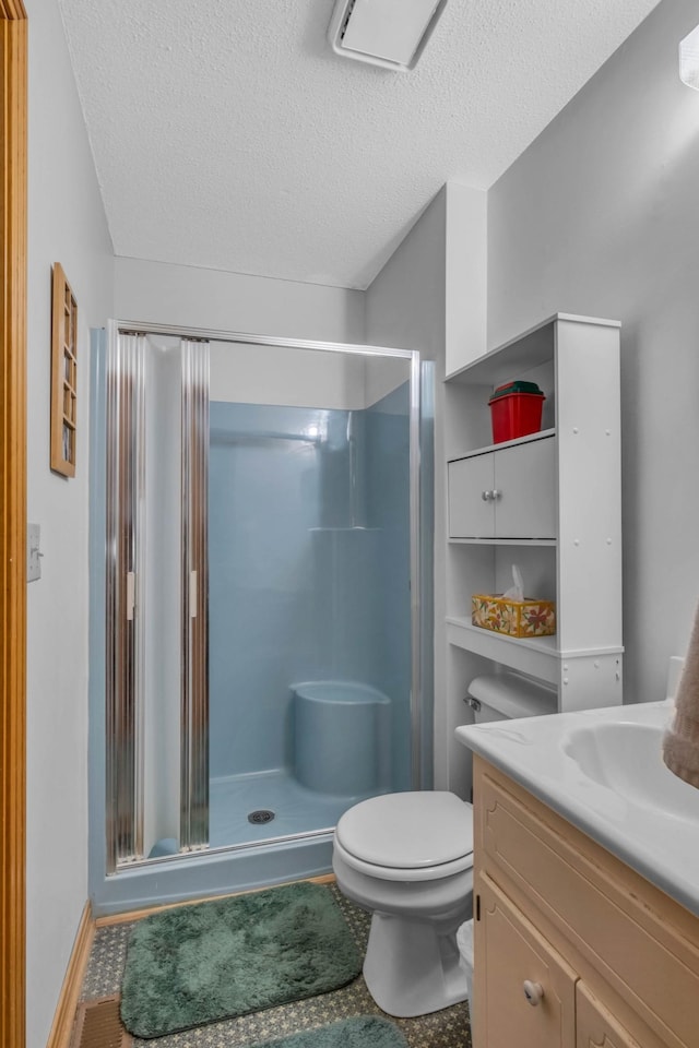 bathroom with a textured ceiling, toilet, vanity, and a shower with door