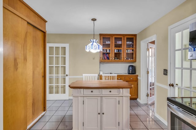 kitchen featuring french doors, white cabinets, hanging light fixtures, and light tile patterned floors