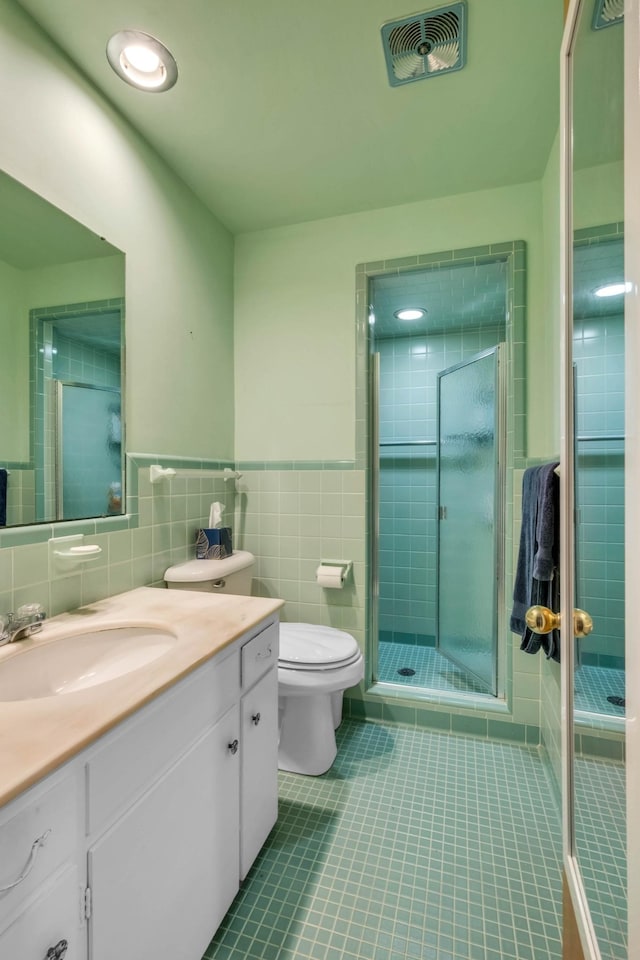 bathroom featuring tile walls, vanity, tile patterned flooring, and a shower with shower door