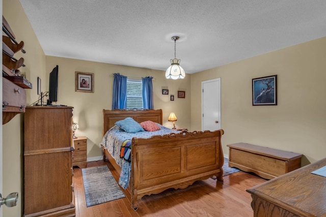 bedroom featuring light hardwood / wood-style flooring and a textured ceiling