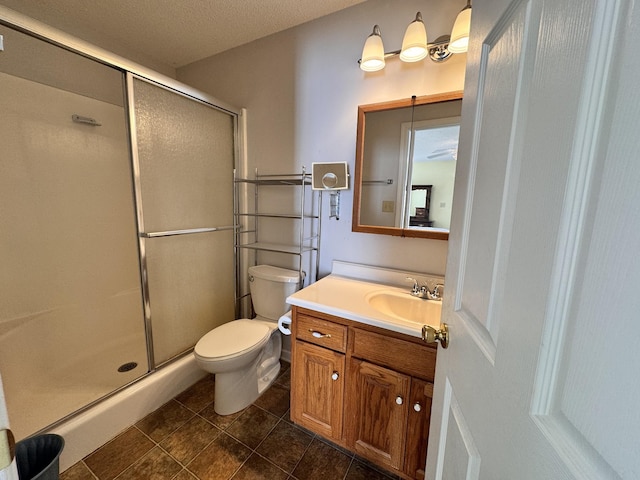 bathroom with a textured ceiling, vanity, toilet, and walk in shower