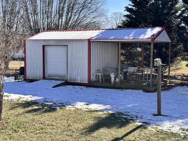 snow covered structure with a garage