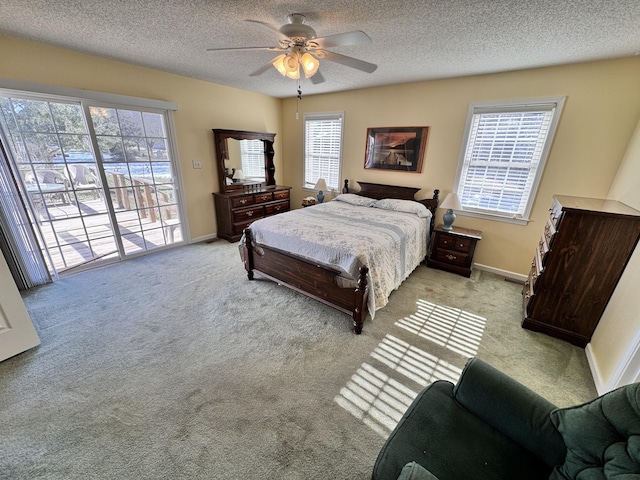 bedroom with multiple windows, access to outside, ceiling fan, and light colored carpet