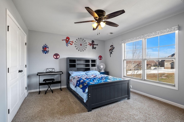 bedroom featuring carpet flooring, ceiling fan, and multiple windows