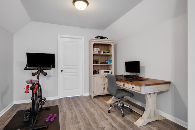 office featuring lofted ceiling and light hardwood / wood-style flooring