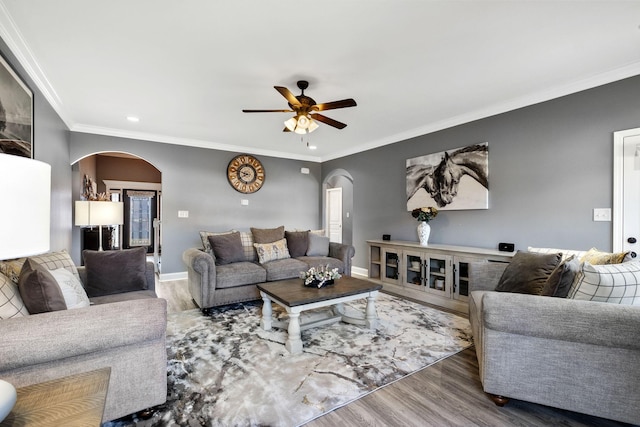 living room featuring hardwood / wood-style floors, ceiling fan, and ornamental molding