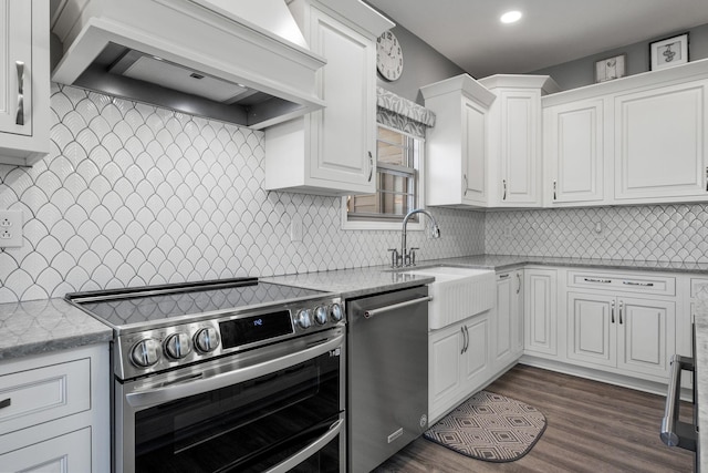 kitchen featuring appliances with stainless steel finishes, tasteful backsplash, custom exhaust hood, sink, and white cabinetry