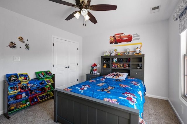 carpeted bedroom with ceiling fan and a closet