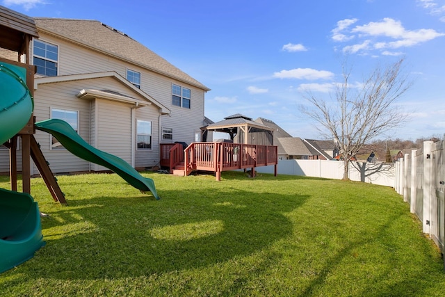 back of property with a gazebo, a deck, and a lawn