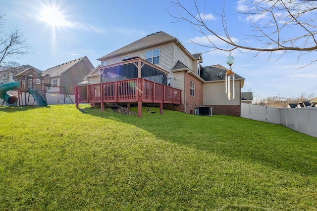 back of house with a playground, central air condition unit, a yard, and a wooden deck