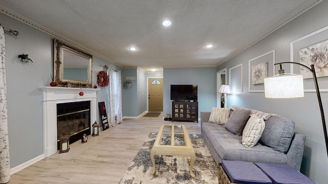 living room featuring a textured ceiling, light hardwood / wood-style flooring, and ornamental molding