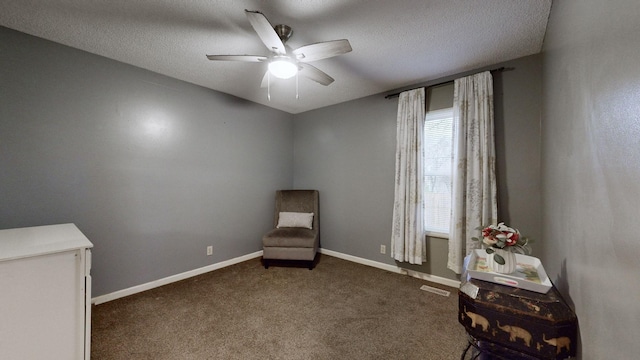 unfurnished room with ceiling fan, dark carpet, and a textured ceiling