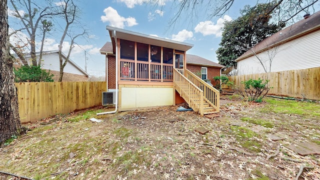 rear view of house with central AC and a sunroom