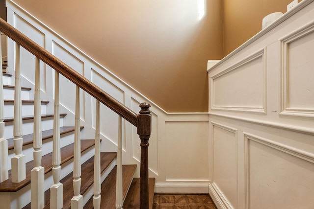 stairs featuring parquet flooring