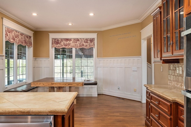 kitchen with a wealth of natural light, tile counters, and ornamental molding