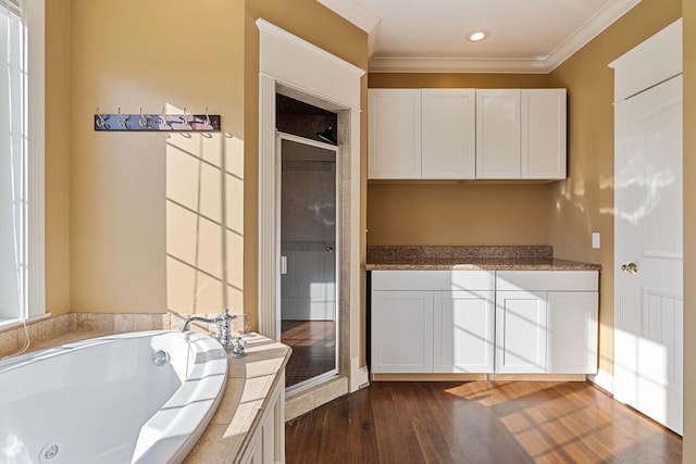 kitchen featuring dark hardwood / wood-style flooring, white cabinetry, and ornamental molding