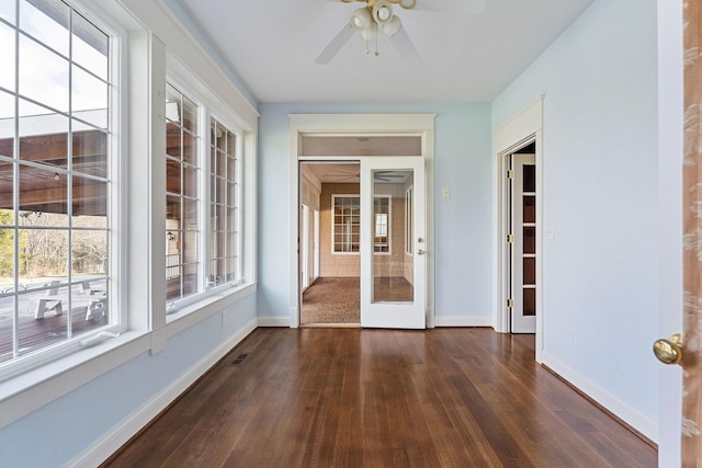 unfurnished sunroom featuring ceiling fan and french doors