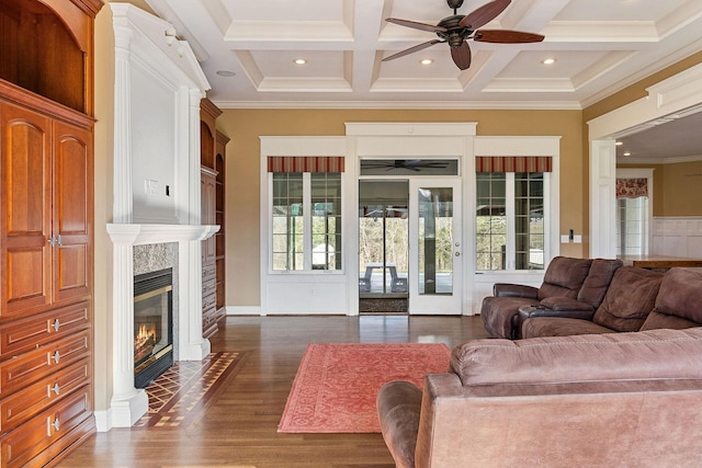 living room with dark wood-type flooring, coffered ceiling, crown molding, ceiling fan, and beamed ceiling