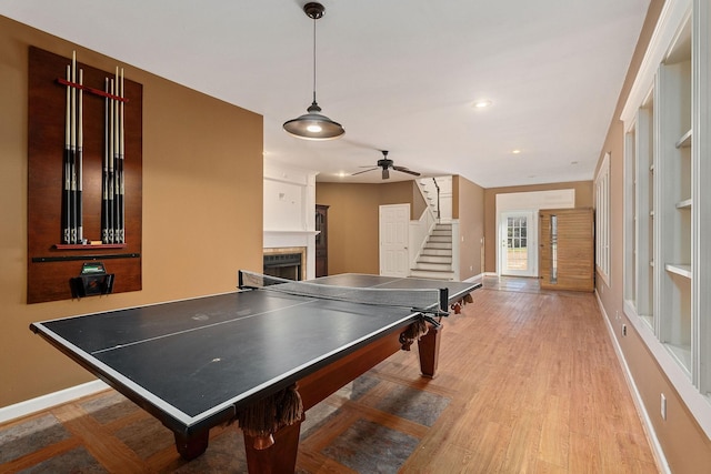 recreation room with ceiling fan and light hardwood / wood-style floors