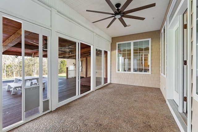 unfurnished sunroom featuring ceiling fan