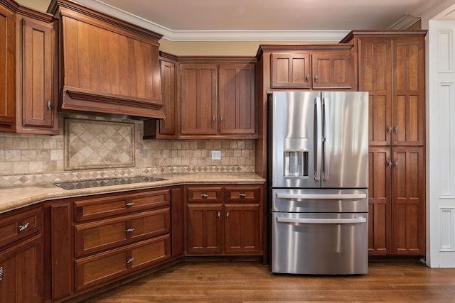 kitchen featuring dark wood-type flooring, stainless steel fridge, decorative backsplash, black electric stovetop, and ornamental molding