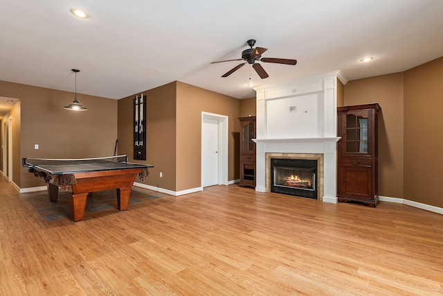 game room with a fireplace, light hardwood / wood-style floors, ceiling fan, and pool table