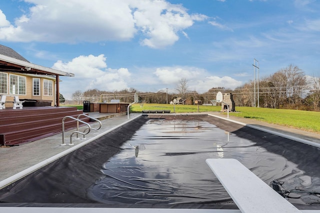 view of swimming pool featuring a yard