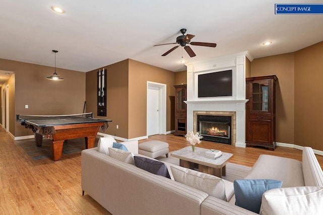 living room with ceiling fan, a fireplace, billiards, and light hardwood / wood-style flooring