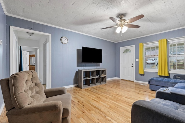 living room featuring wood-type flooring, ceiling fan, and crown molding