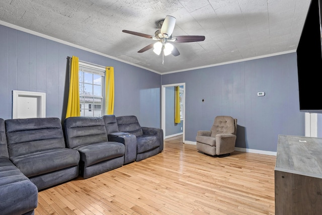 living room with ceiling fan, light hardwood / wood-style floors, crown molding, and wooden walls