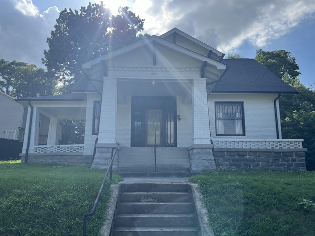 view of front of property with covered porch and a front yard