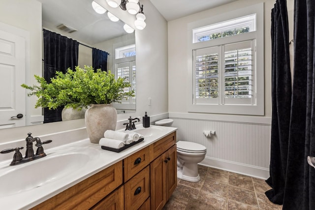 bathroom featuring vanity, toilet, and a wealth of natural light