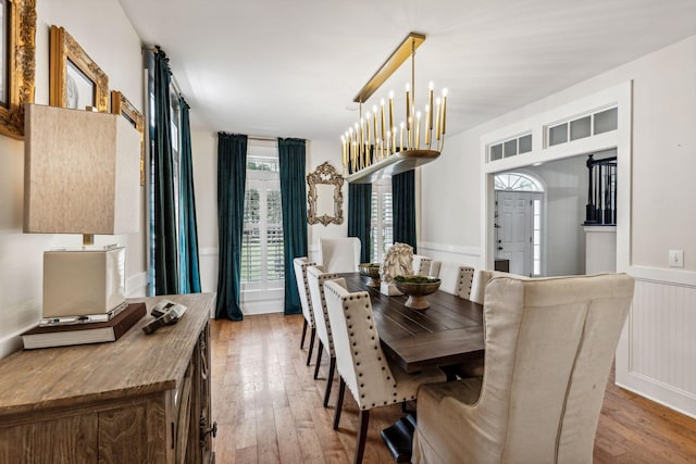 dining area featuring hardwood / wood-style flooring and an inviting chandelier